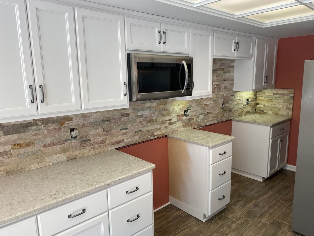 Stacked-stone kitchen backsplash with white cabinets and quartz counters, built by PRZ in Mooresville